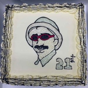 A 21st birthday cake with a portrait of a man drawn in icing